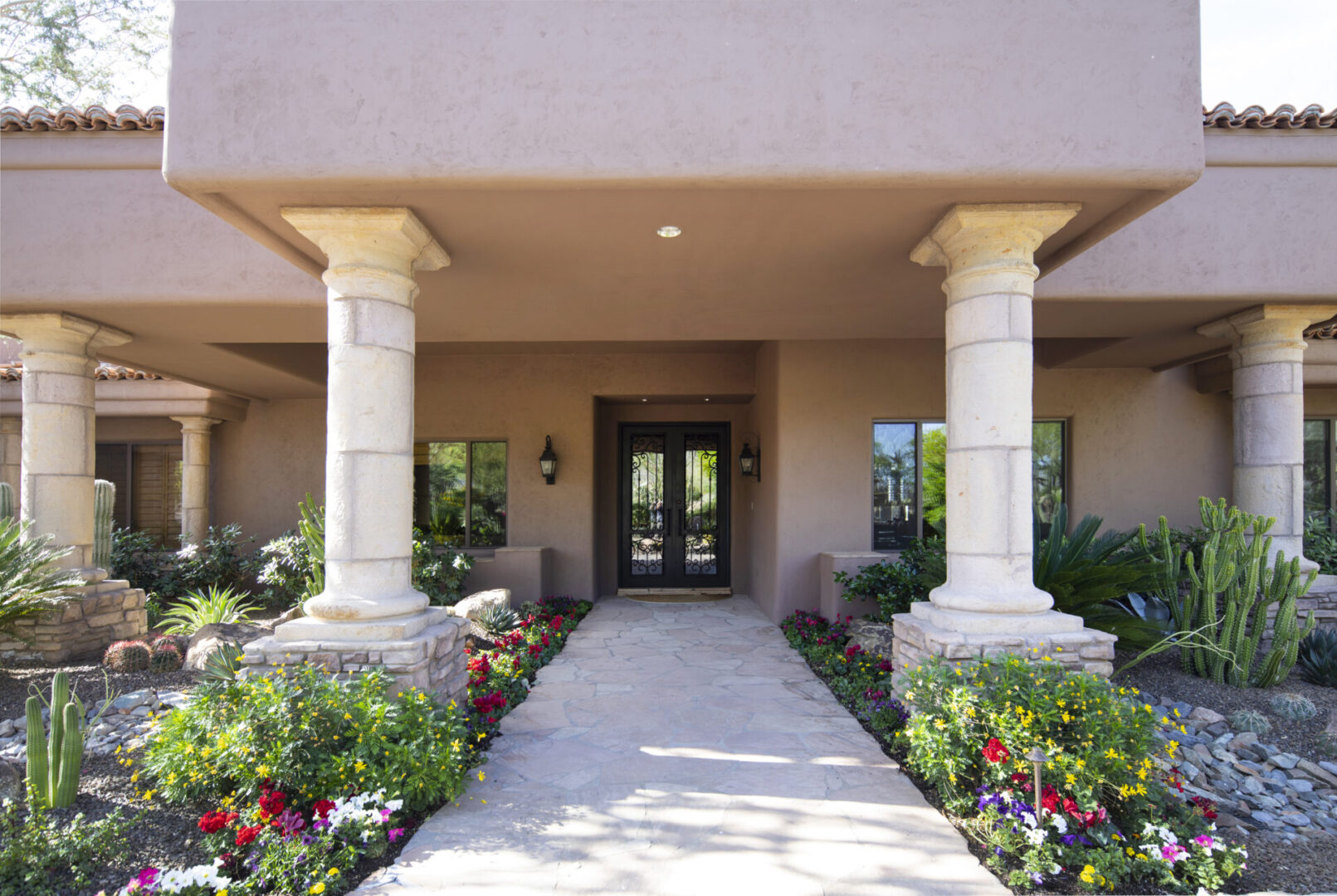 A walkway with pillars and flowers in the center.