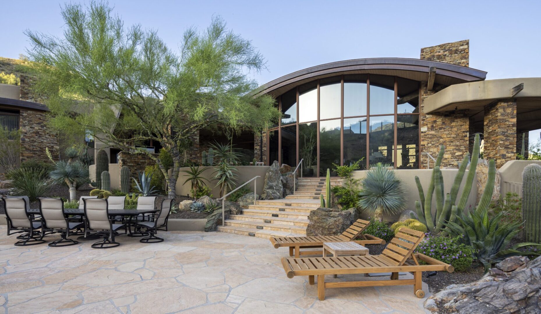 A patio with chairs and tables outside of a house.