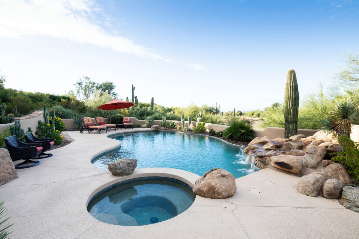 A pool with two hot tubs in it.