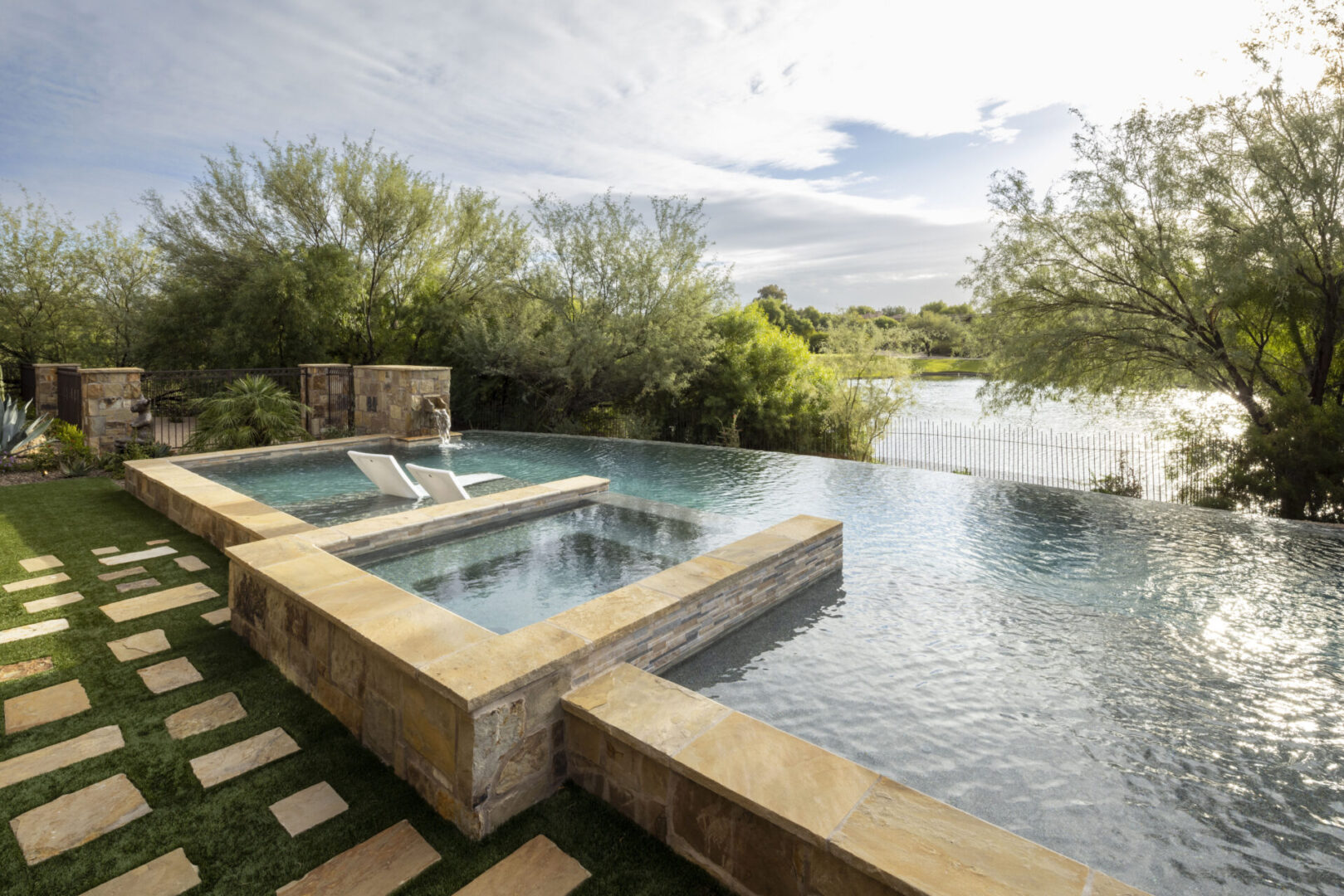 A pool with two jets and a waterfall.