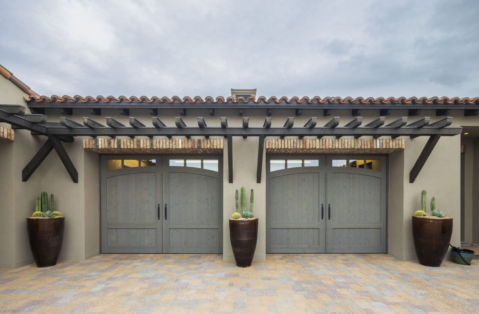 A pair of garage doors with a potted plant in the middle.