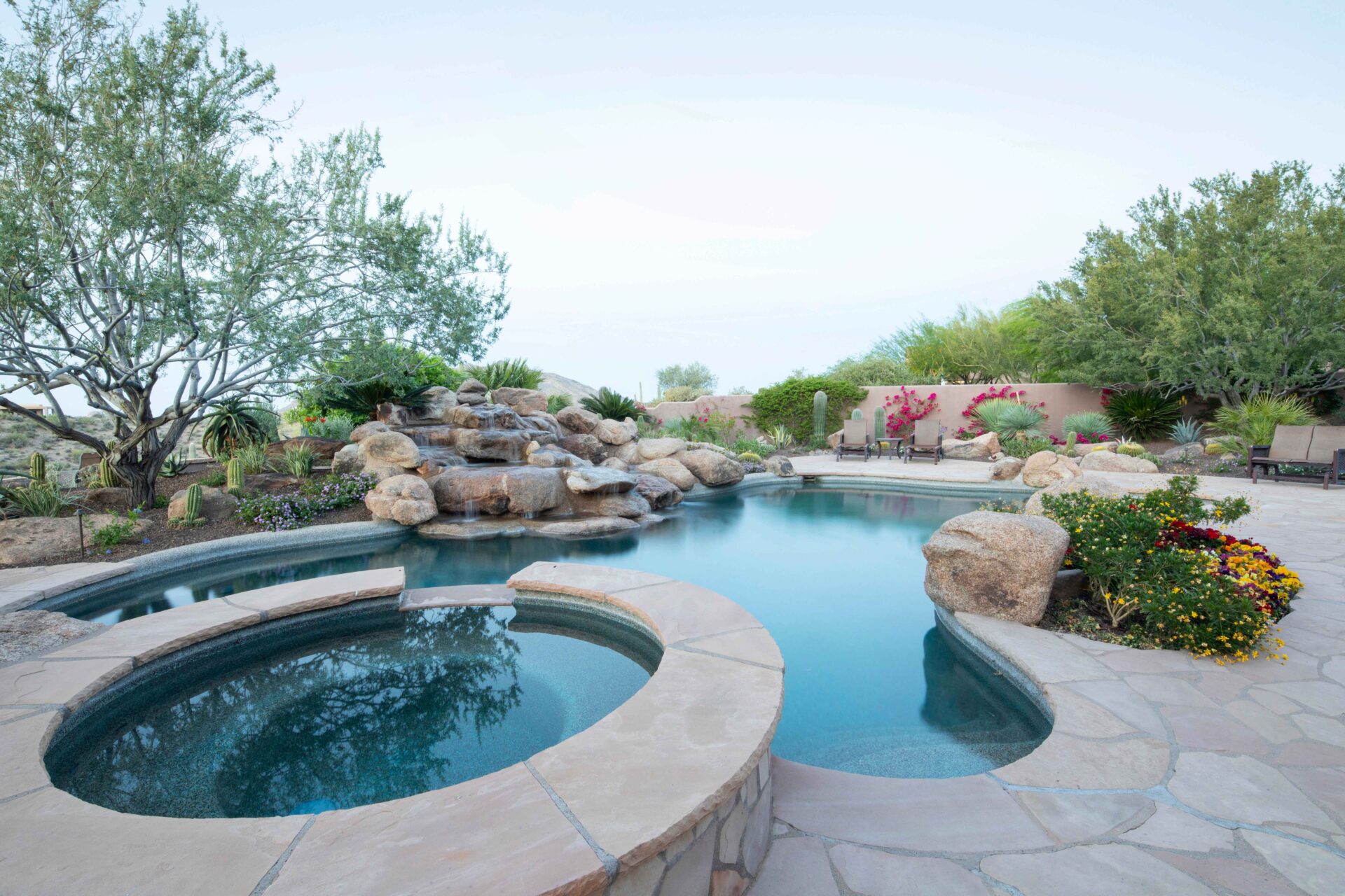 A pool with a jacuzzi and a waterfall