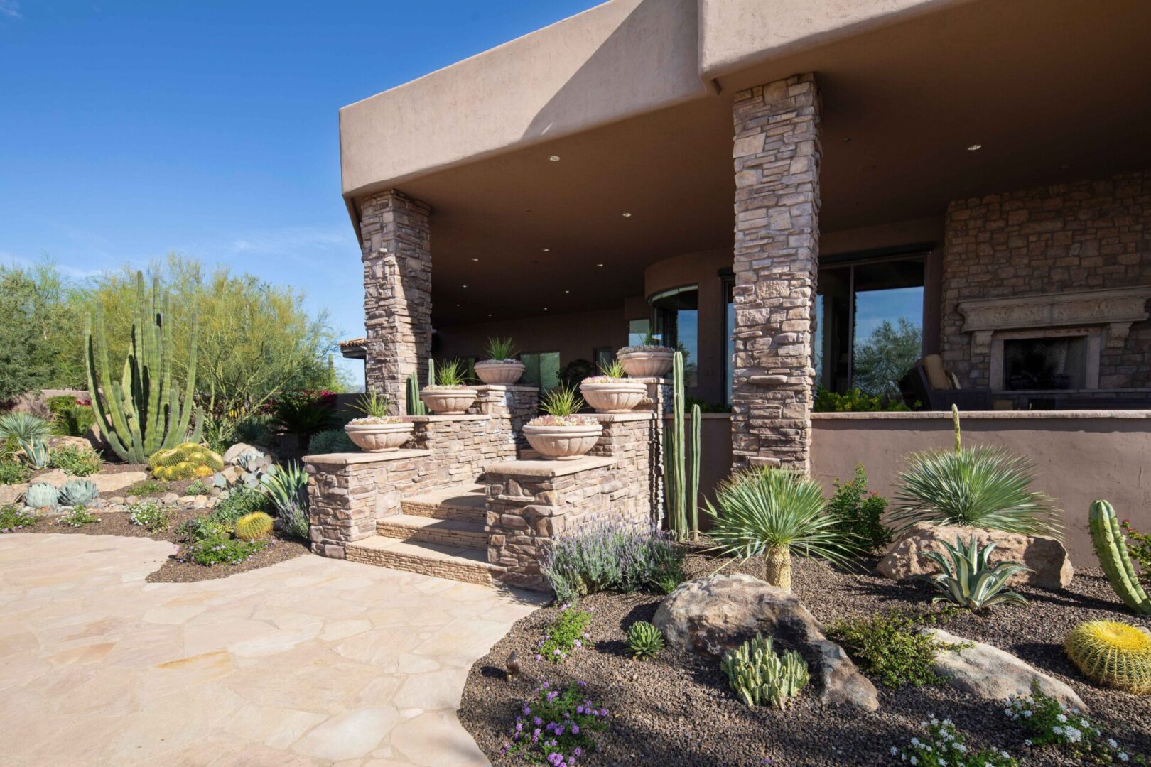 A patio with steps and plants in the middle of it.