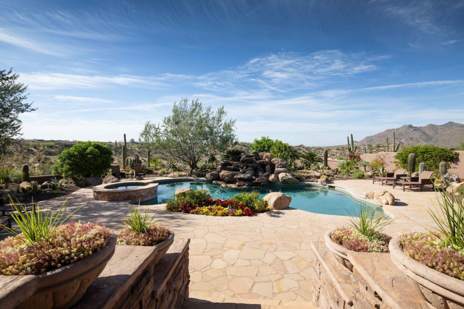 A pool with a rock wall and water features.