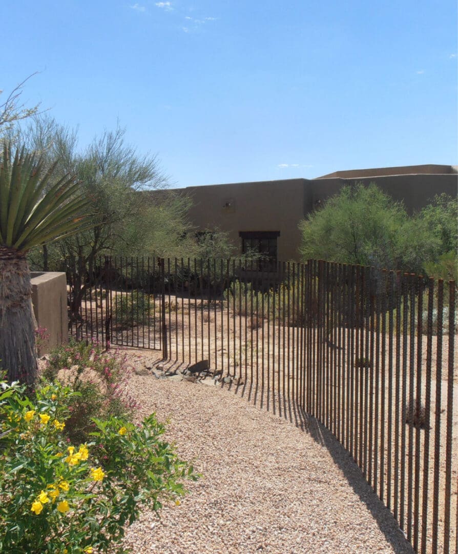 A fenced in area with flowers and bushes.