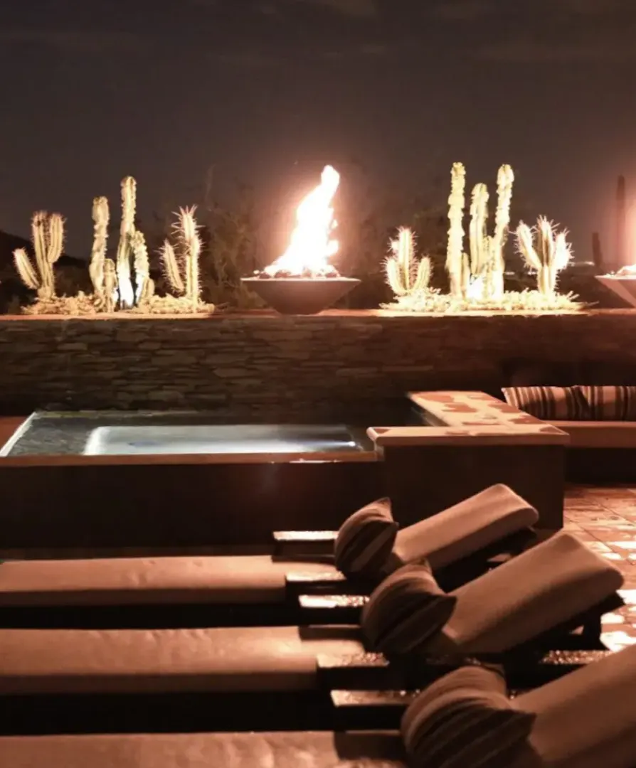 A fire pit with logs and candles in the background.