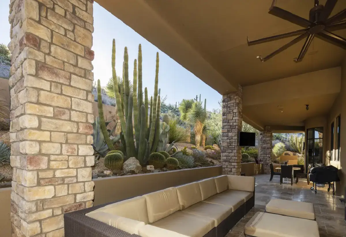 A patio with couches and a table in the middle of it