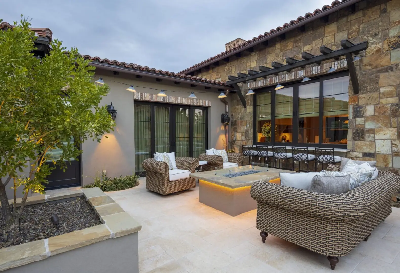 A patio with furniture and fire pit in the middle of it.