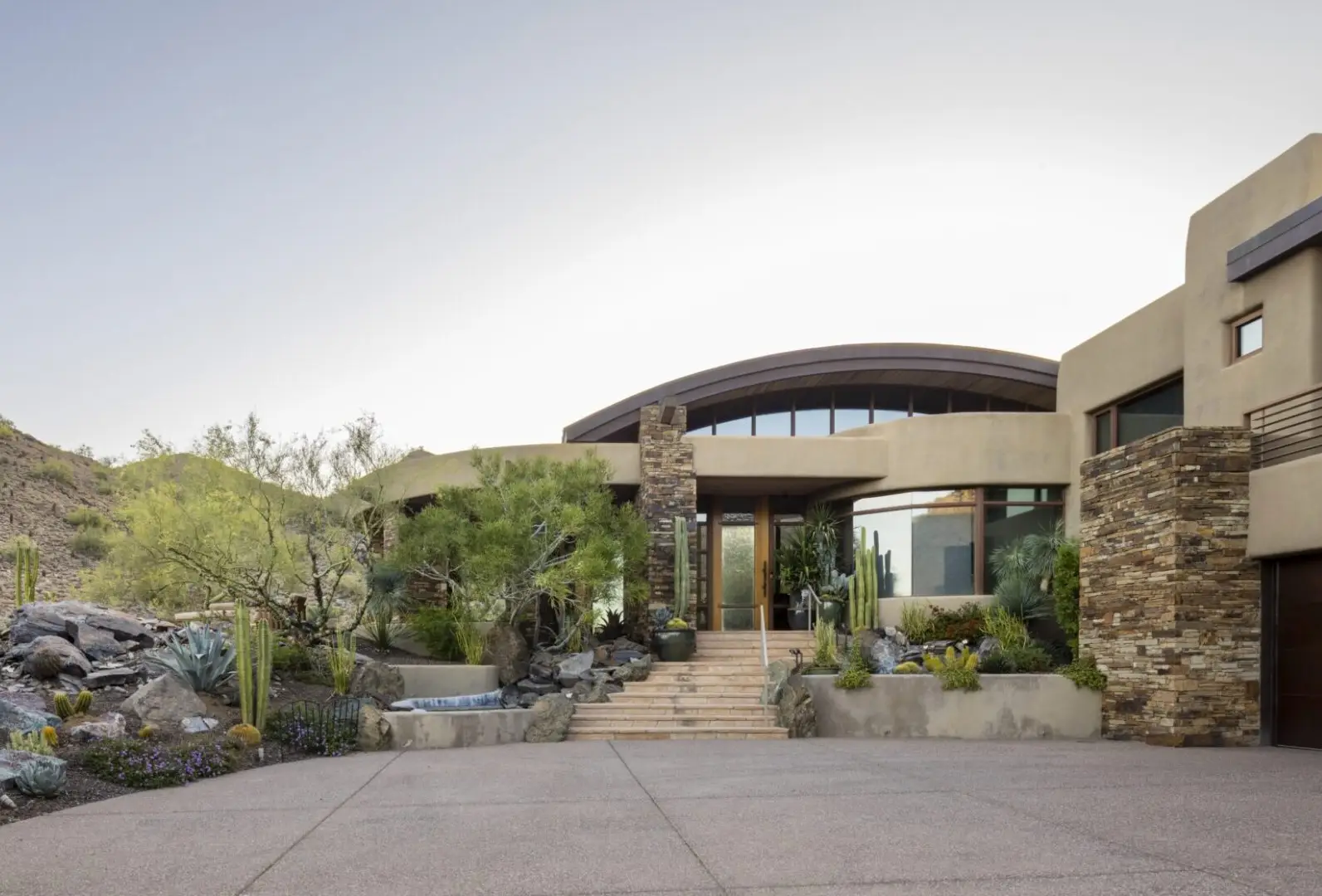 A large house with a lot of plants in front