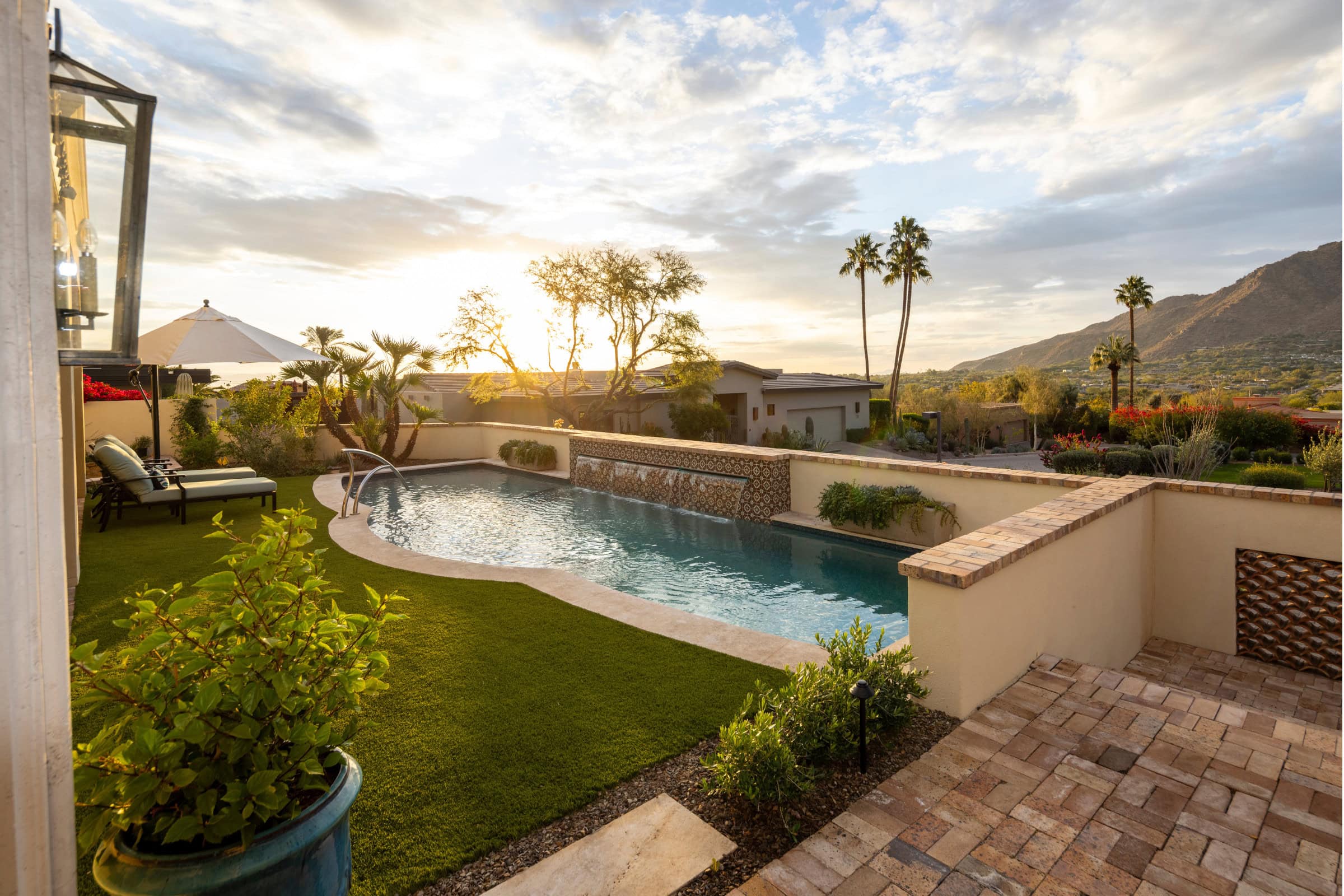 A backyard with outdoor living features including a pool.