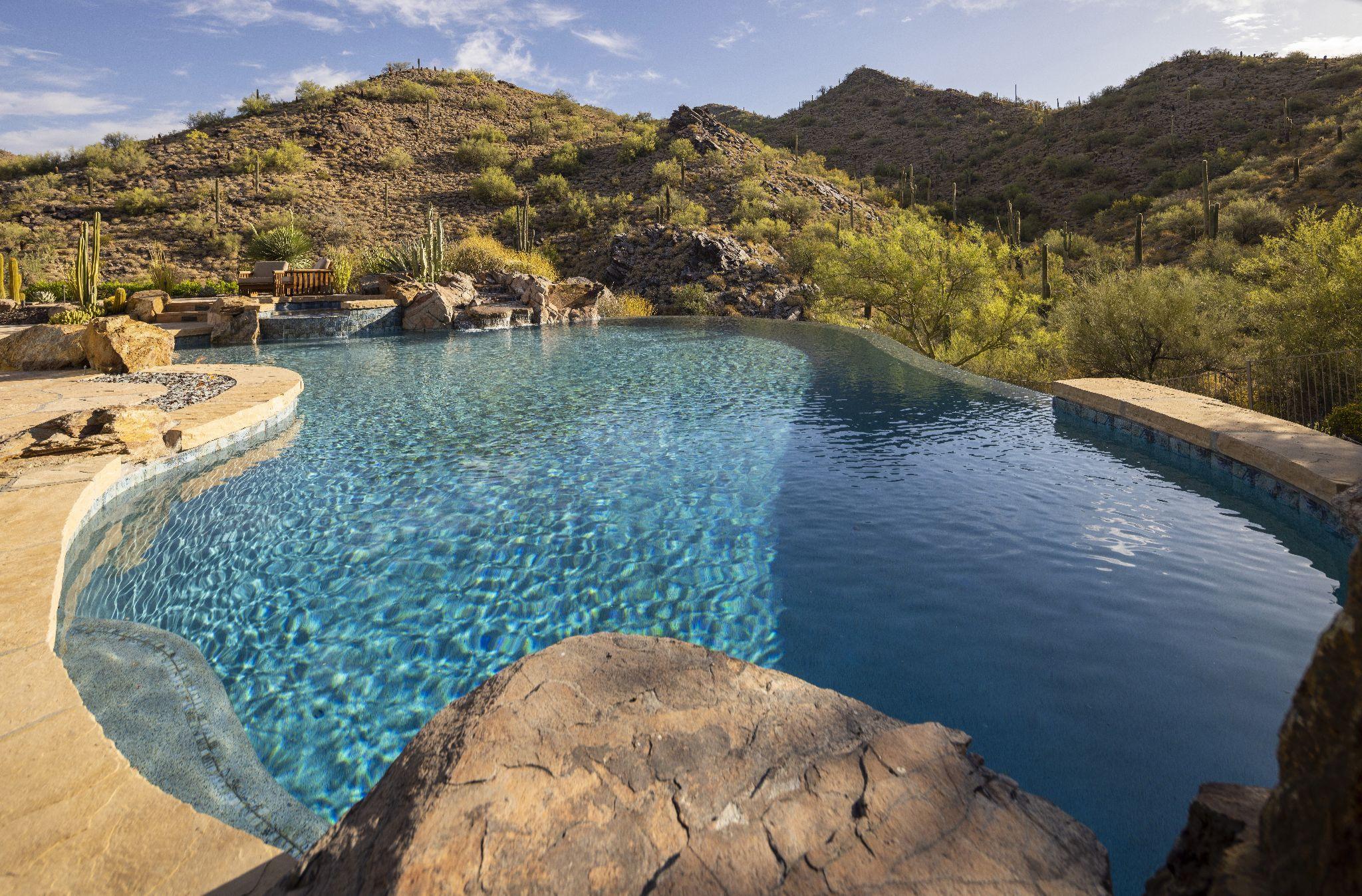 Infinity pool beside desert trees and natural surroundings