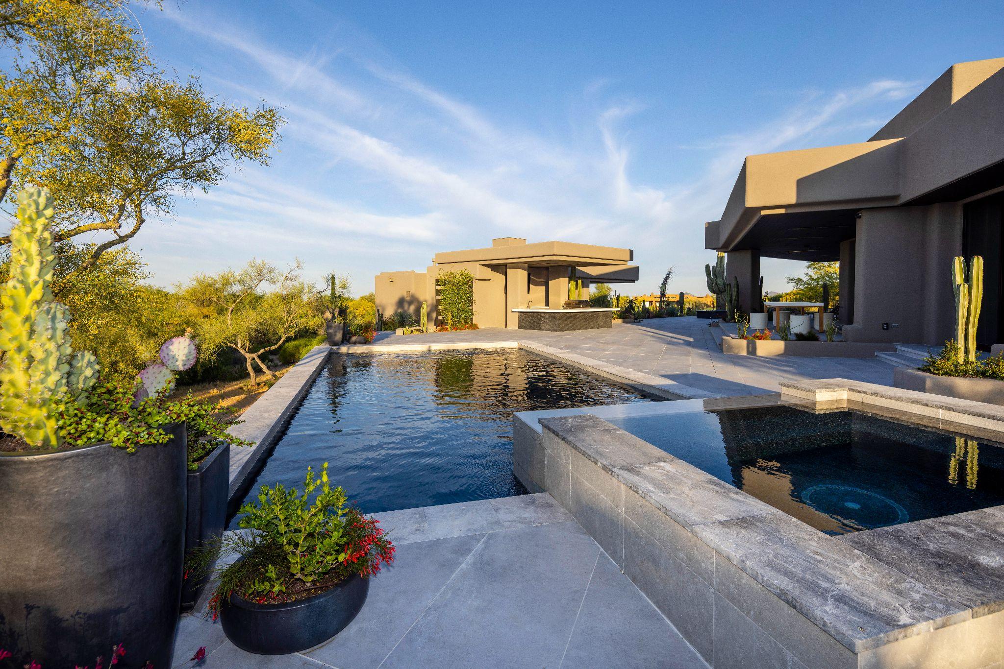 Modern desert pool with integrated spa and outdoor living areas